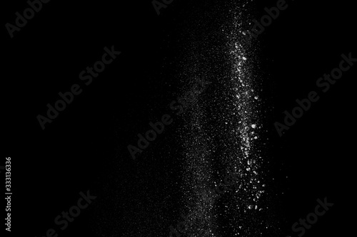 White dust similar to flour and snow is actively scattered isolated on black background