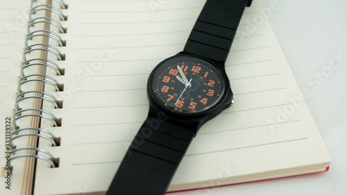 The black wristwatch is put on the pocket watch.