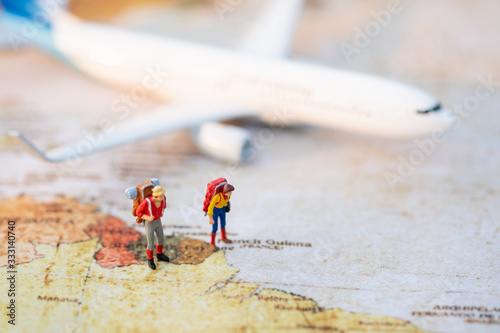 Miniature people: Group backpacker on vintage world map with airplane using as business trip traveler adviser agency or explorer on earth background concept.