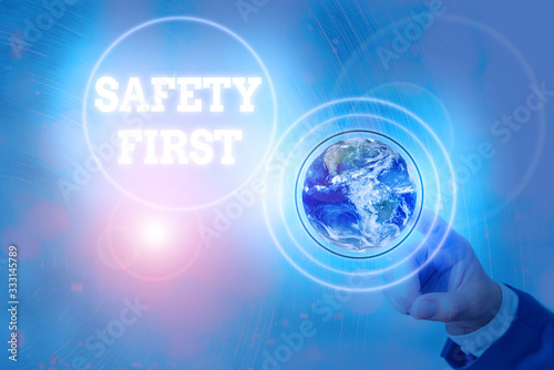 Writing note showing Safety First. Business concept for used to say that the most important thing is to be safe Elements of this image furnished by NASA photo