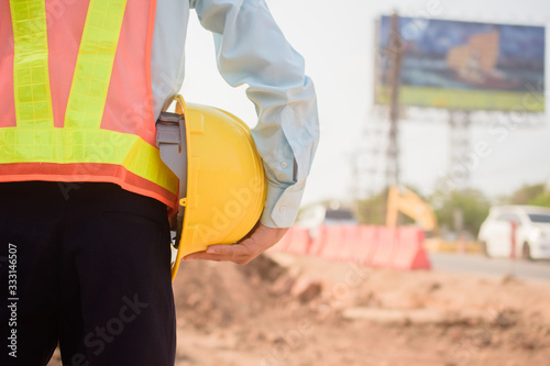 Supervisor holding hard hat at construction site