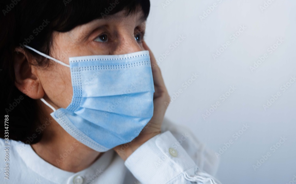 Coronavirus quarantine and Air pollution pm2.5 concept. Face of old sick woman wearing blue respirator mask for protect. Wuhan, China epidemic virus symptoms background. Coronavirus quarantine and Air pollution pm2.5 concept. Face of old sick woman wearing blue respirator mask for protect. Wuhan, China epidemic virus symptoms background.