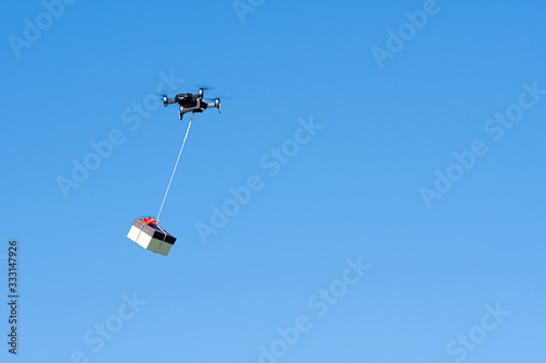 drone flying with a gift box isolated on a blue sky