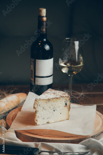Composition with wine and Flatley cheese. Cheese with a blue noble mold on a wooden Board.