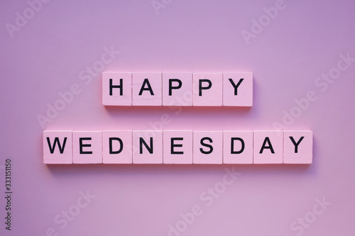 Happy wednesday words wooden cubes on a pink background photo