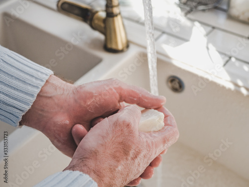 Men s hands and a bar of soap on a background of a vintage tap. Top view  closeup. Health Care and Prevention Concept
