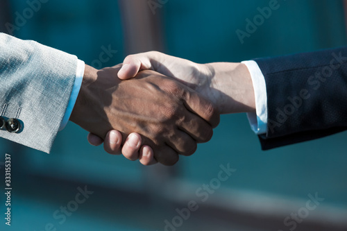 Business leaders meeting and greeting each other with handshake. Business man and woman in office jackets shaking hands. Successful deal concept