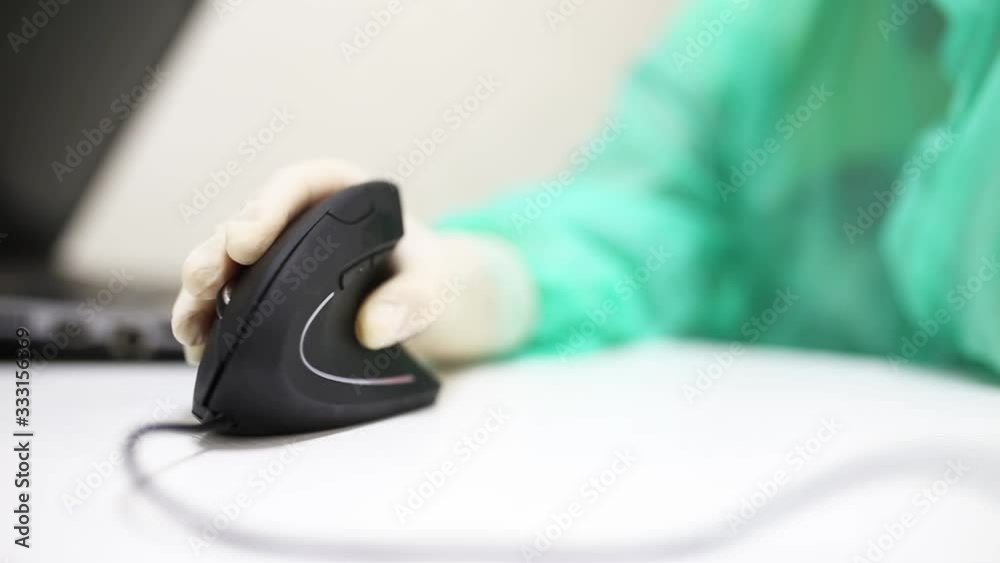 hand of a medical scientist uses a vertical ergonomic computer mouse-joystick. hand of a medical scientist uses a vertical ergonomic computer mouse-joystick.