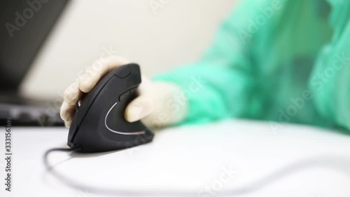 hand of a medical scientist uses a vertical ergonomic computer mouse-joystick. photo