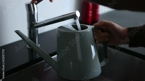Watering the flowers. Man pours water into watering can