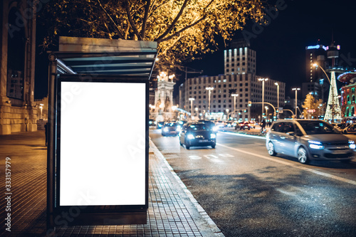 Night shot of a luminous advertising lightbox or display at a bus stop in Barcelona, Spain
