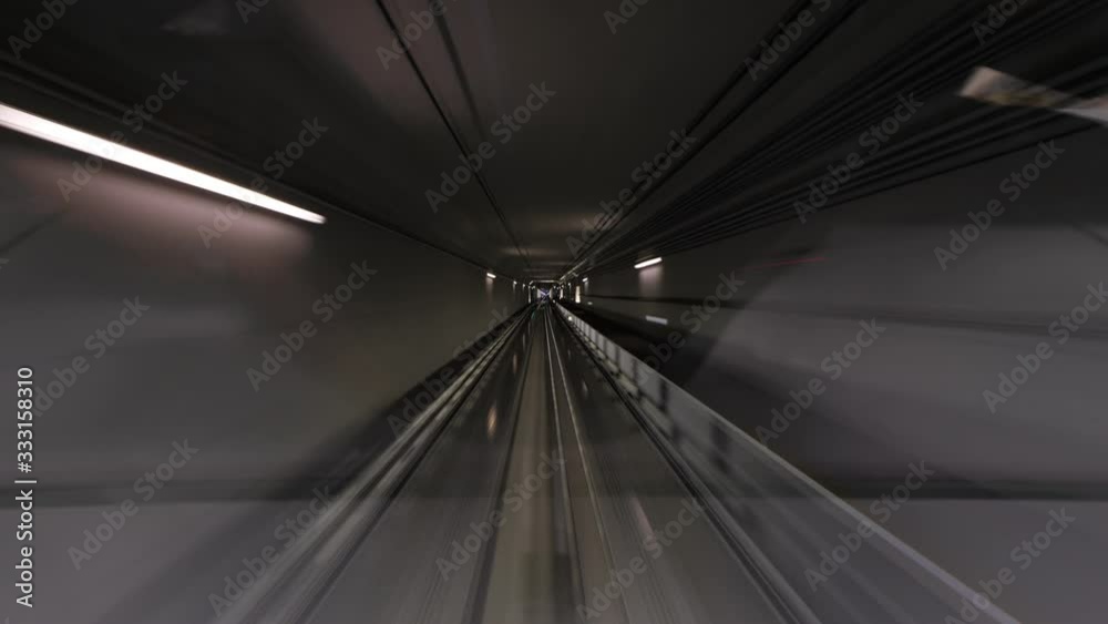 Automated people mover rush at tunnel, view through cabin windshield, driver window perspective. Time lapse shot, fast motion forward, dark walls seen in motion blur Automated people mover rush at tunnel, view through cabin windshield, driver window perspective. Time lapse shot, fast motion forward, dark walls seen in motion blur