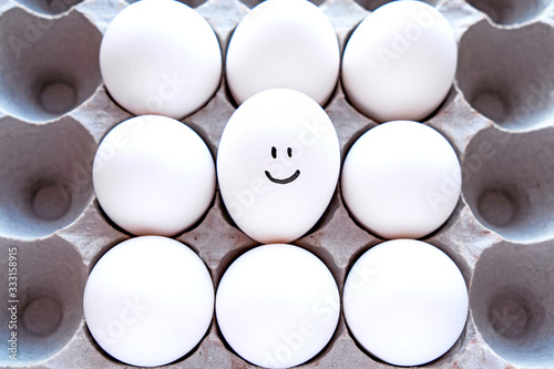 White eggs in a package on a blue background close-up view from above. 