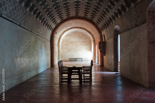 Single tables and chairs inside the cloister at Actopan Mexico photo