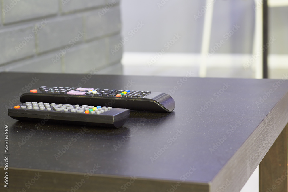 two remote controls are on the table in the room two remote controls are on the table in the room