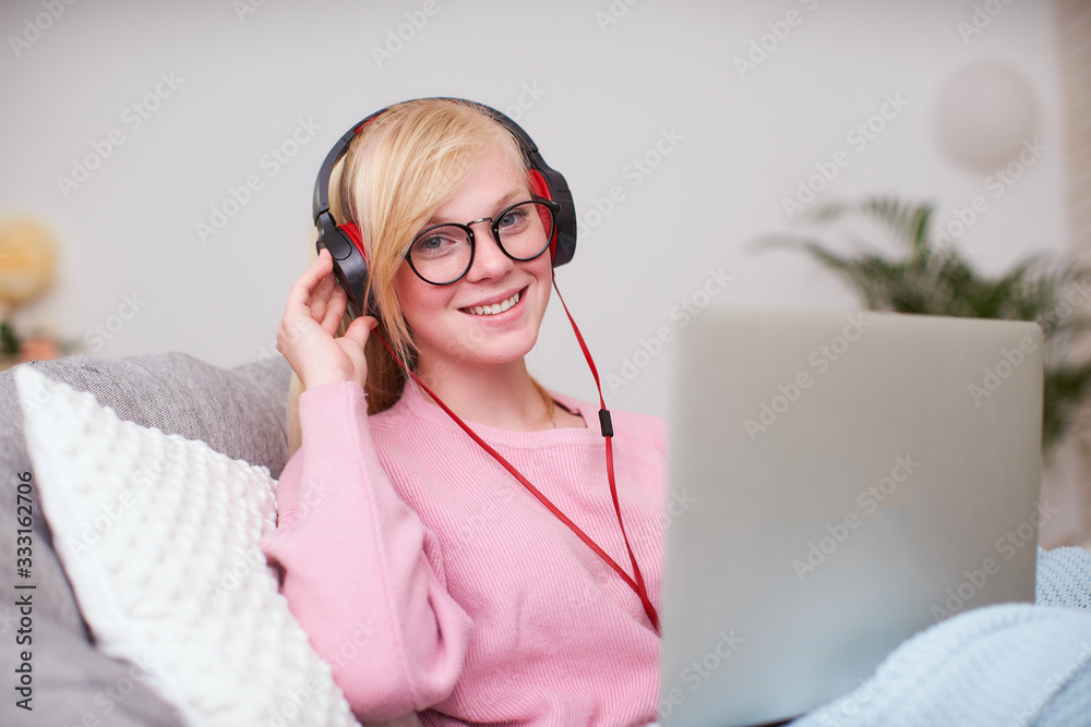 Naklejka premium Girl student happy to communicate with friends headphones via Internet