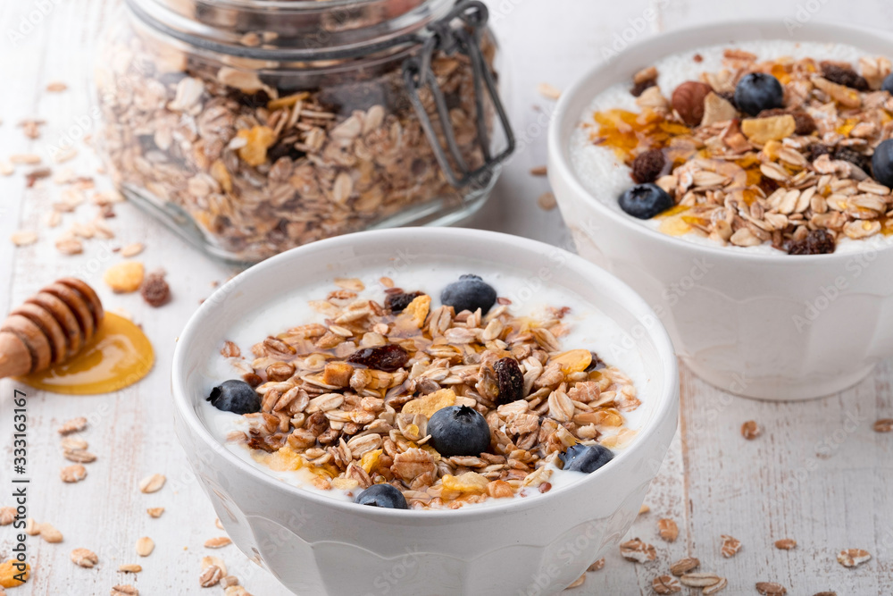 Muesli in a bowl on white wooden background Muesli in a bowl on white wooden background