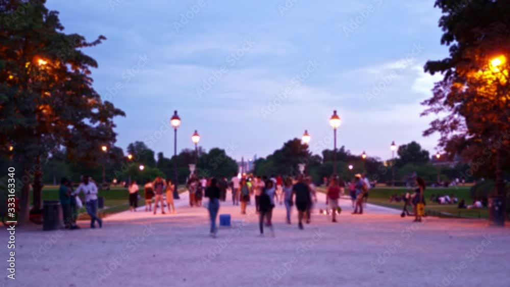 Time Lapse. Defocused view of the pedestrian street of Paris. Park area, tourists walk along the avenue. Street lights light up. Clouds move slowly in the sky. Day to night TimeLapse. Ultra HD footage Time Lapse. Defocused view of the pedestrian street of Paris. Park area, tourists walk along the avenue. Street lights light up. Clouds move slowly in the sky. Day to night TimeLapse. Ultra HD footage