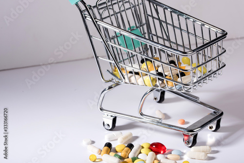 Pills spilled out of shopping cart, top view. Medication and medicine tablets. Copy space