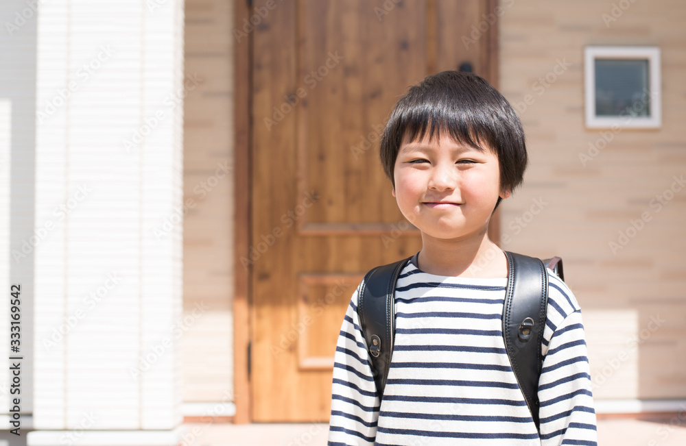 家の前でランドセルを背負った小学生の男の子 家の前でランドセルを背負った小学生の男の子