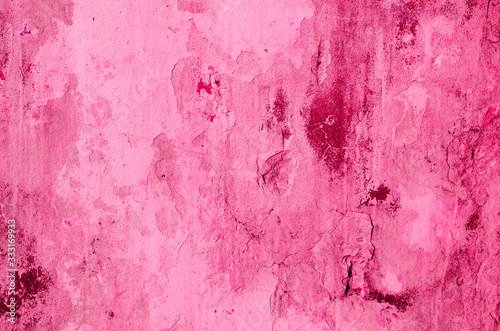 Fragment of old house wall close-up. Pink background. Peeling plaster on concrete surface. Cracks in paint. Copy space. Place for text. Selective focus image.