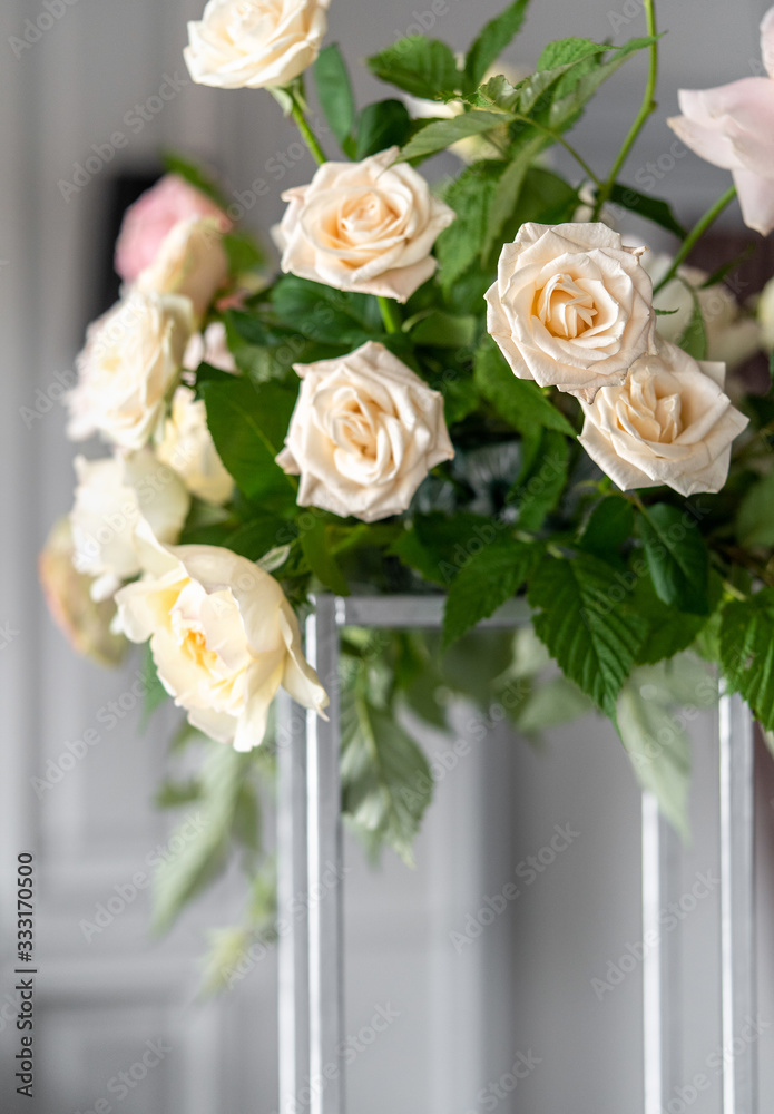 Bouquet of white roses with raspberry leaves on the table. Dressing at a wedding.