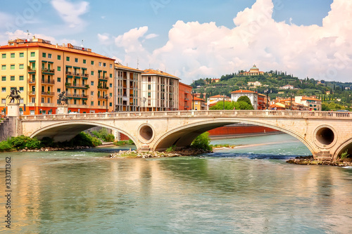 Obraz na plátne Urban riverscape with old historic bridge and buildings, Verona, Italy