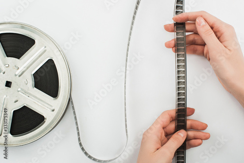 partial view of man holding film strip on white background