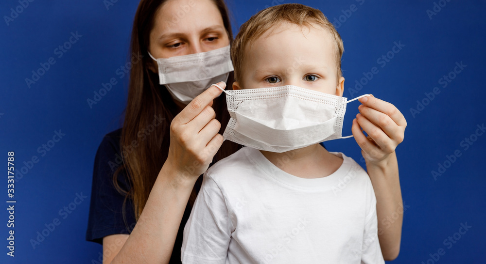 Doctor or nurse puts a protective mask on the little boy. Personal protective equipment against viruses and infections. Flu or coronavirus.