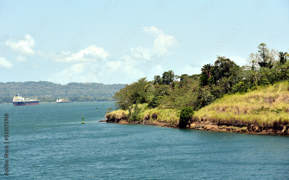 Green landscape of Panama Canal, view from the transiting cargo ship.