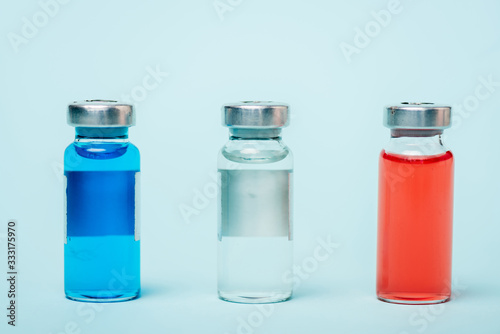 Close up view of colored jars with hormonal drugs on blue surface