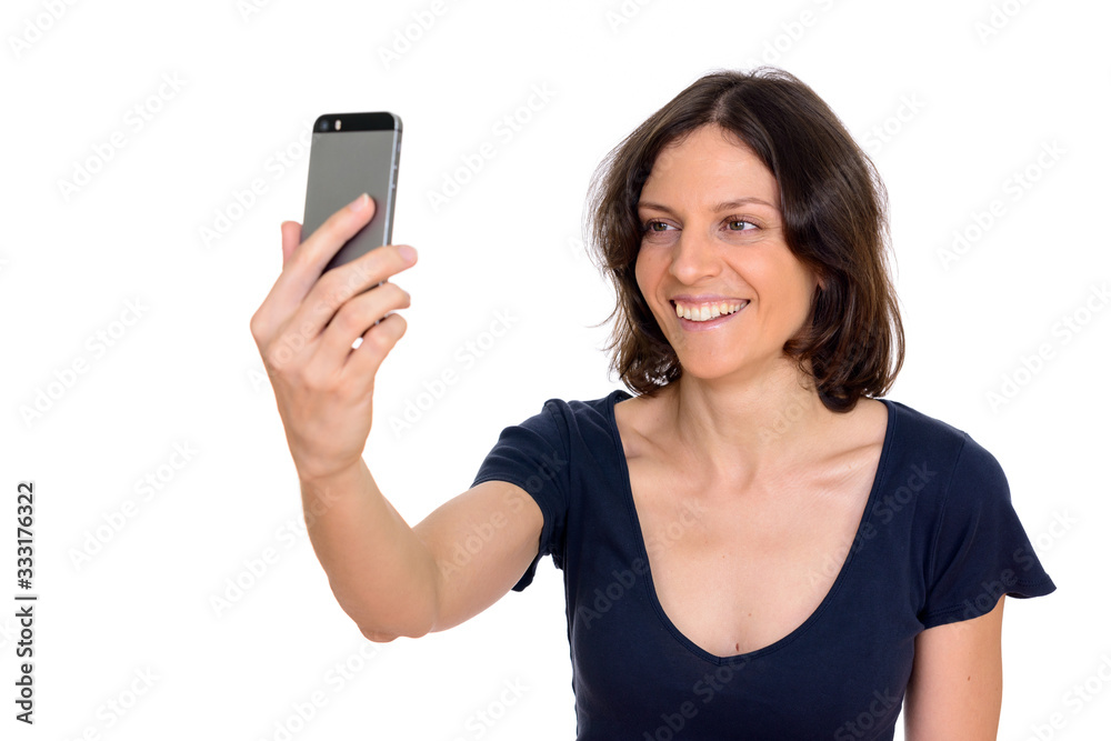 Studio shot of beautiful woman taking selfie isolated against white background Studio shot of beautiful woman taking selfie isolated against white background