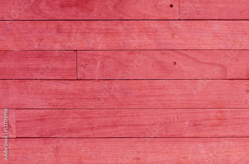 Bright pink wooden backdrop, boards. Red tinted wood. Fragment of fence, floor or wall of building made of wooden boards, place for text. Copy space.