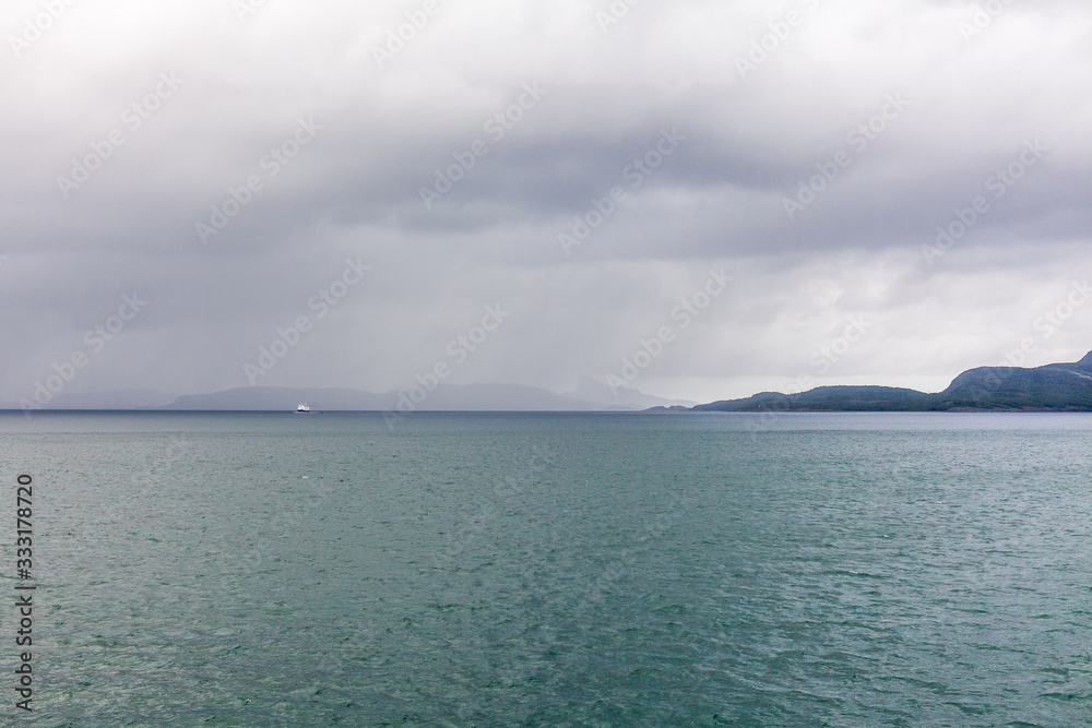 Beautiful view of the Norwegian fjords with turquoise water surrounded by cloudy sky, selective focus