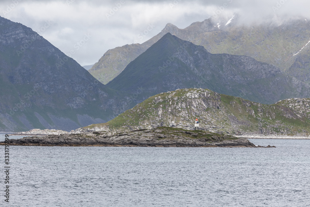 Norwegian fjord and mountains surrounded by clouds, ideal fjord reflection in clear water. selective focus.