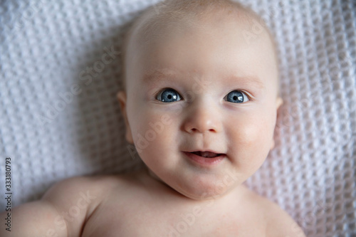 Close up of an adorable 6 month old baby with blue eyes looking at the camera