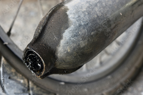 Engine oil stains at the end of the exhaust pipe.