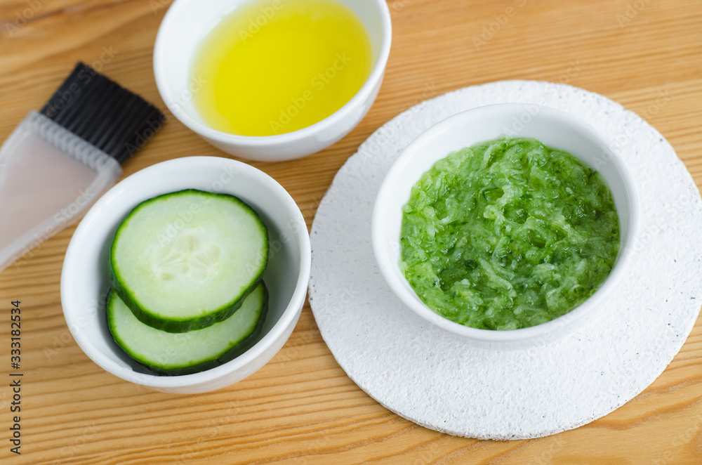 Cucumber puree, cucumber slices and olive oil. Ingredients for preparing homemade facial mask or skin toner. Natural beauty treatment recipe, skip care and zero waste concept. Top view, copy spac Cucumber puree, cucumber slices and olive oil. Ingredients for preparing homemade facial mask or skin toner. Natural beauty treatment recipe, skip care and zero waste concept. Top view, copy spac