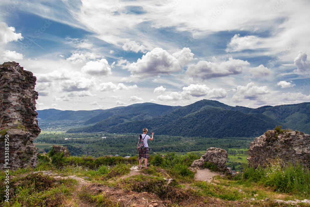 Fototapeta woman tourist takes phone mountain view
