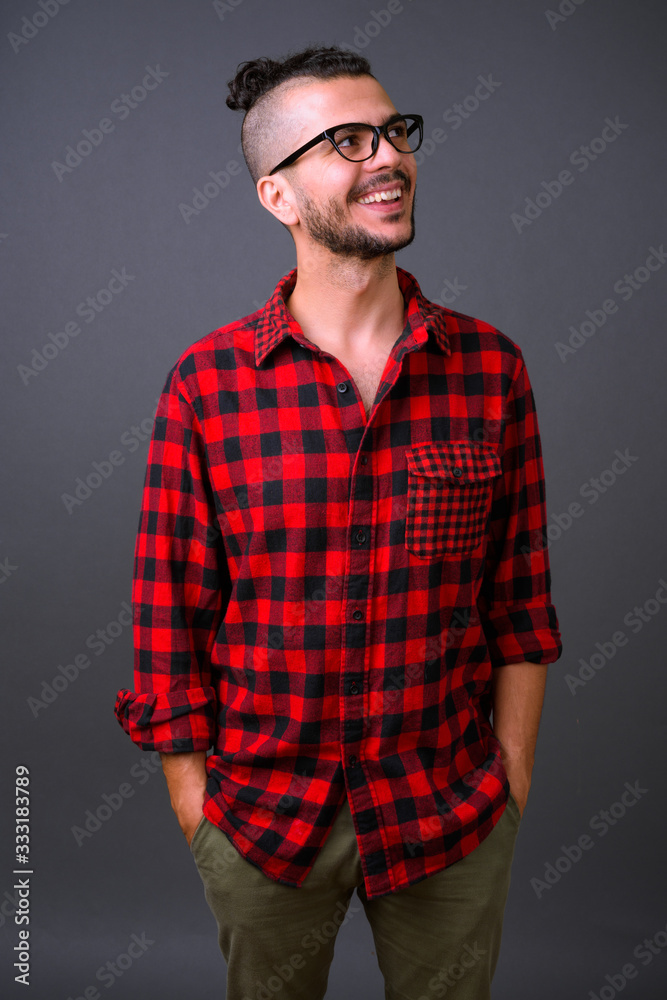 Happy handsome bearded Turkish hipster man with eyeglasses thinking Happy handsome bearded Turkish hipster man with eyeglasses thinking