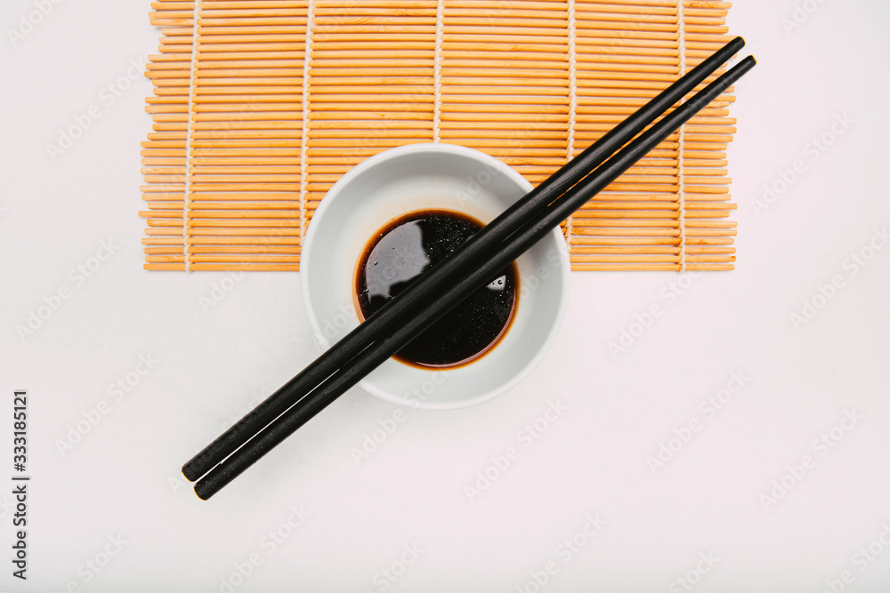 Stock photo of soy bowl with chopsticks on top on a cook mat and white background Stock photo of soy bowl with chopsticks on top on a cook mat and white background
