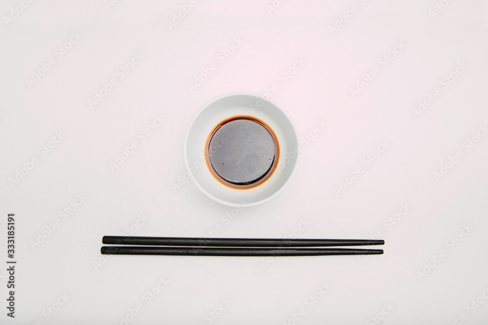 Stock photo of soy bowl with black chopsticks underneath on a white background. Stock photo of soy bowl with black chopsticks underneath on a white background.