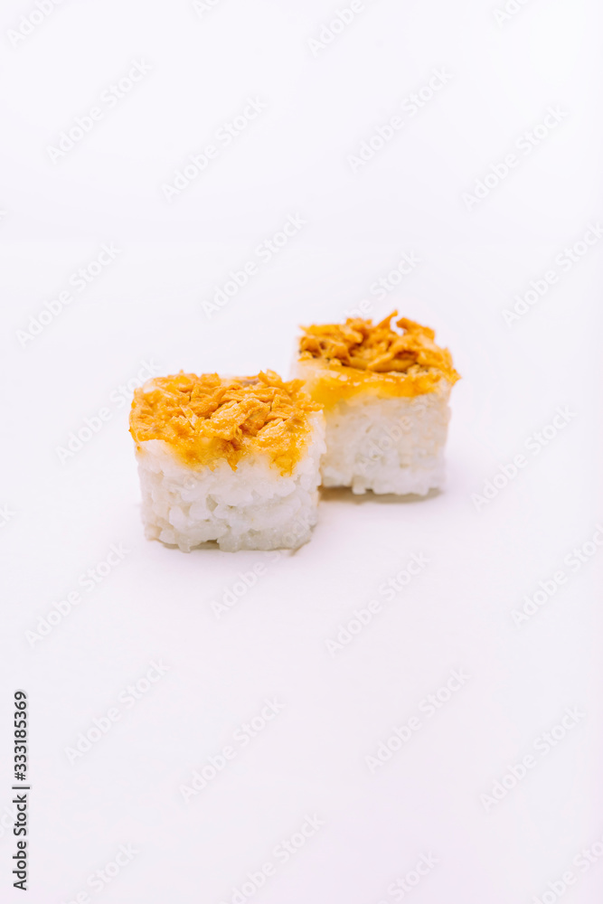Stock photo of two rice maki with dried onion on top on white background.