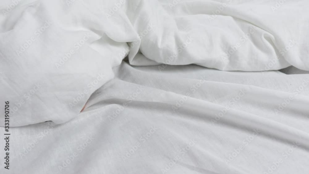 naked beautiful legs under a white blanket. both legs were under the covers. naked beautiful legs under a white blanket. both legs were under the covers.