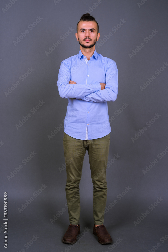 Full body shot of handsome bearded Turkish businessman with arms crossed Full body shot of handsome bearded Turkish businessman with arms crossed