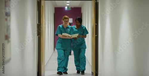 Two Medical Staff Walk Through Corridor photo