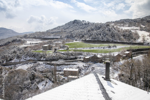 Snowy roof with chimney and snowy mountain in the background