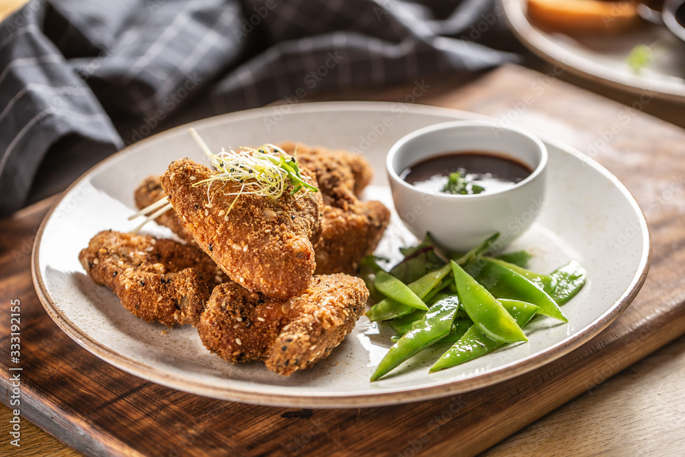 Fried chicken wings with sugar peas and herbs