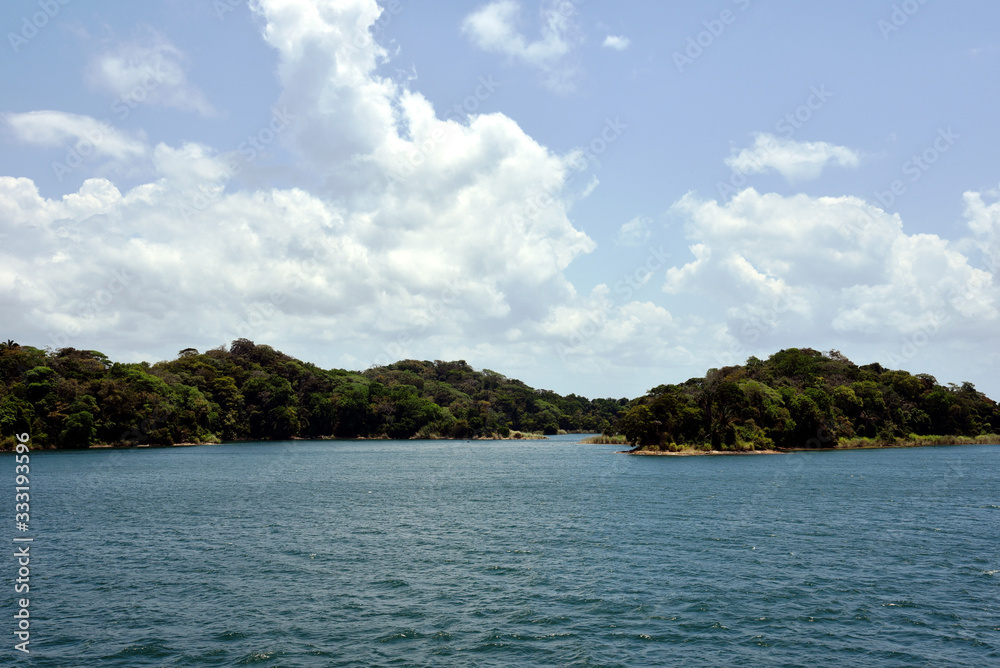 Green landscape of Panama Canal, view from the transiting cargo ship.