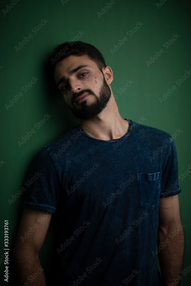 Portrait of young brunette Indian Kashmiri man in casual tee shirt in green copy space studio background. lifestyle and fashion. Portrait of young brunette Indian Kashmiri man in casual tee shirt in green copy space studio background. lifestyle and fashion.